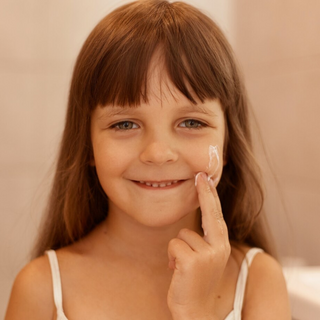 Ein lachendes Kind mit aufgetragener Baby-Zart Gesichtscreme von Pure Elements im Gesicht – vegane, glutenfreie Naturkosmetik mit echten Bergkristallen, tierversuchsfrei, BDIH-zertifiziert und hergestellt in Deutschland