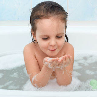 Ein Kind sitzt in der Badewanne mit Wasser und Schaum, hat die Hände voller Schaum und pustet darauf – es verwendet das Baby-Rein 2 in 1 von Pure Elements. Milde, vegane Naturkosmetik, glutenfrei, tierversuchsfrei, BDIH-zertifiziert und hergestellt in Deutschland