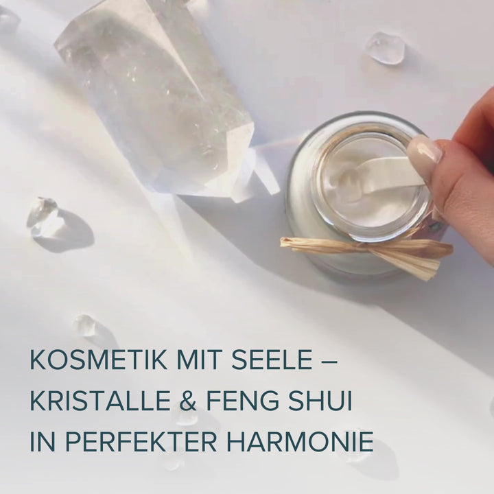 Videoaufnahme für Mobilgeräte: Eine Creme von Pure Elements wird geöffnet und mit einem kleinen Kosmetikspachtel sanft gerührt. Im Inneren ist ein echter Bergkristall sichtbar, der anschließend mit dem Spachtel aus der Creme gehoben wird. Weitere Bergkristalle sind zu sehen. Unten im Video erscheint der Text: „Kosmetik mit Seele – Kristalle und Feng Shui in perfekter Harmonie“.
